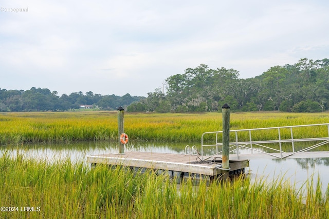 view of dock with a forest view and a water view