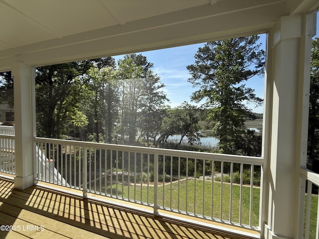 wooden deck with a yard and a water view