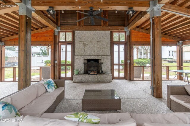 living room featuring ceiling fan, a tile fireplace, and a high ceiling