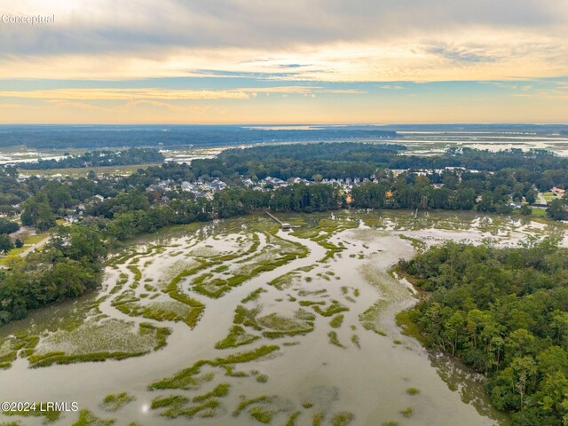 aerial view at dusk featuring a water view