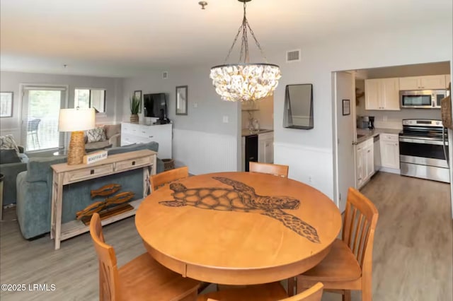 663 William Hilton Pkwy Unit 442, Hilton Head Island, SC 29928 - dining area featuring light wood-style flooring and a chandelier