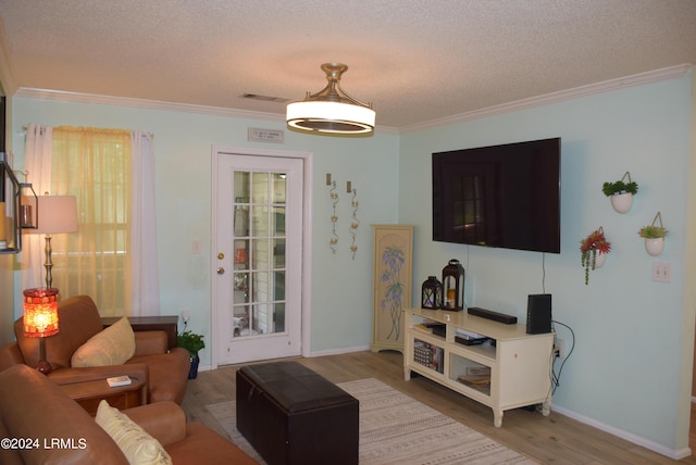 living room featuring hardwood / wood-style flooring, crown molding, and a textured ceiling