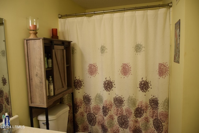 bathroom featuring a shower with shower curtain and toilet