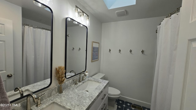 bathroom with a skylight, baseboards, a sink, and toilet