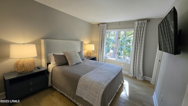 bedroom featuring light wood-style floors and baseboards