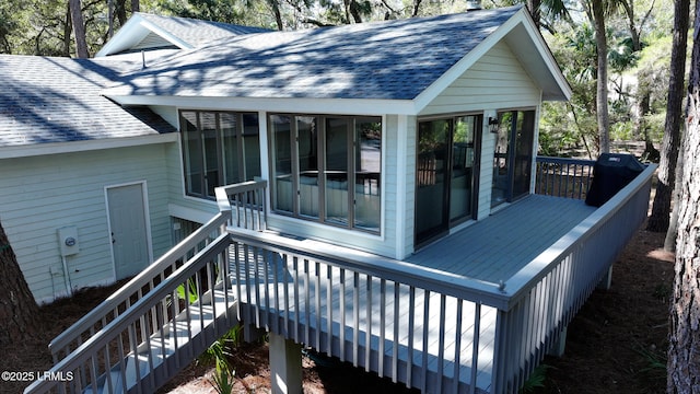 wooden deck featuring a sunroom and stairway