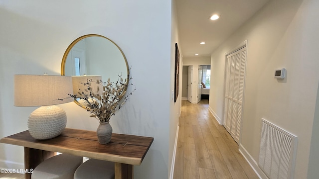 hall with light wood-style floors, baseboards, visible vents, and recessed lighting