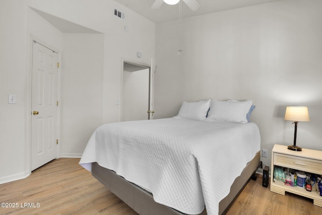 bedroom featuring a ceiling fan, wood finished floors, visible vents, and baseboards