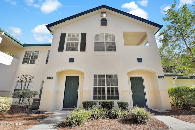 view of front facade with central air condition unit and stucco siding