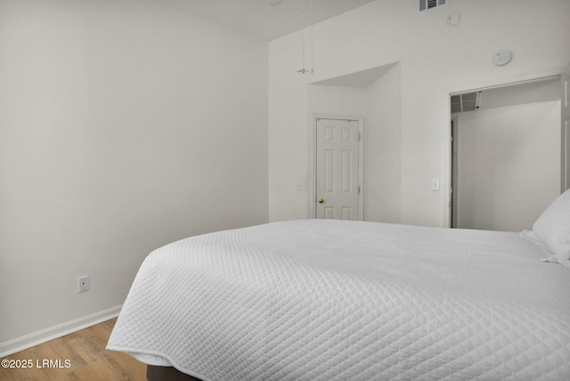 bedroom featuring wood finished floors, visible vents, and baseboards