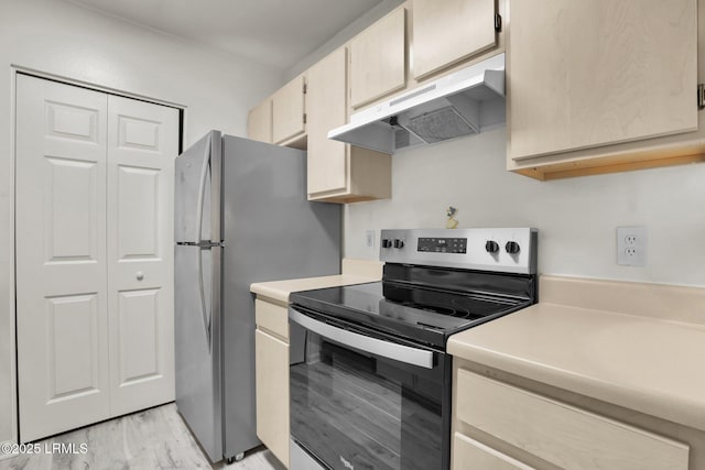 kitchen featuring appliances with stainless steel finishes, light countertops, under cabinet range hood, and light wood finished floors