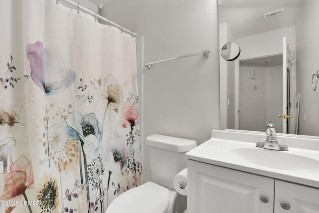 bathroom featuring toilet, curtained shower, vanity, and visible vents