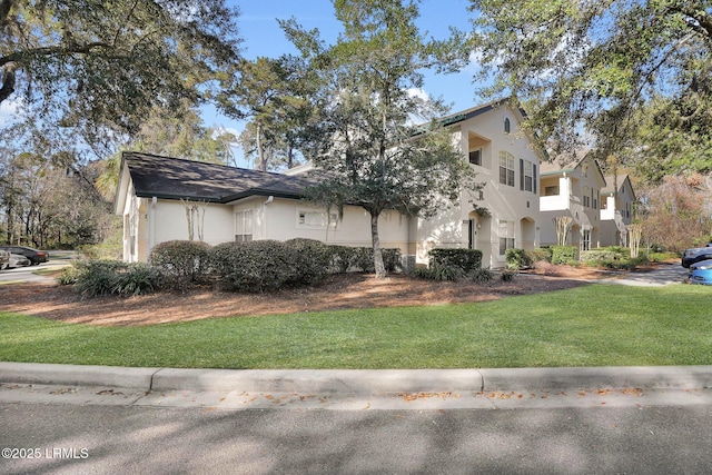 view of front of property featuring a front lawn and stucco siding