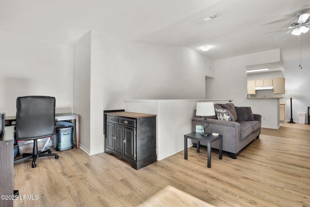 interior space featuring light wood-type flooring, visible vents, ceiling fan, and baseboards