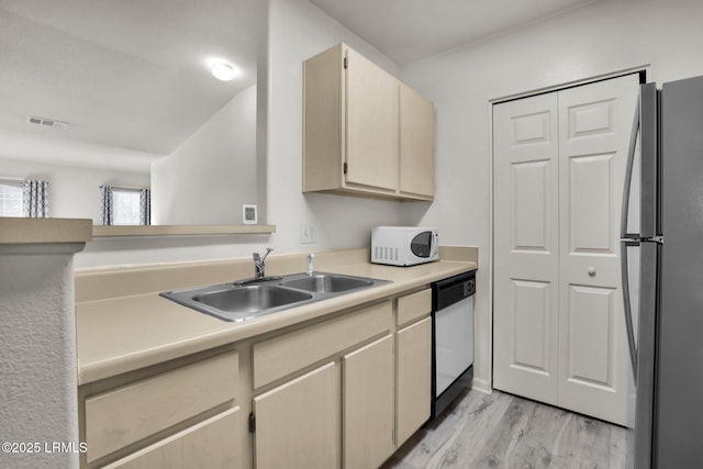 kitchen featuring light countertops, white appliances, a sink, and visible vents