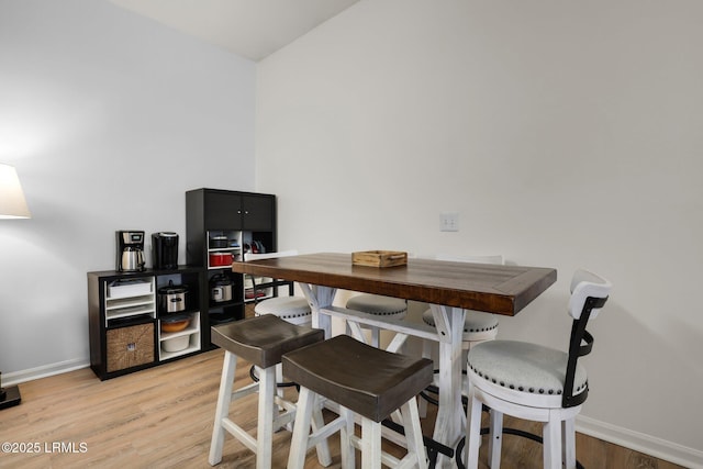 dining room featuring light wood-type flooring and baseboards