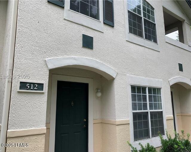 property entrance with stucco siding