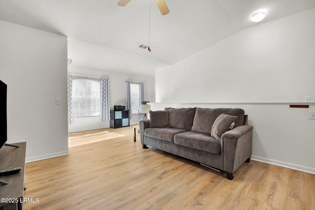 living area with baseboards, visible vents, ceiling fan, vaulted ceiling, and light wood-type flooring