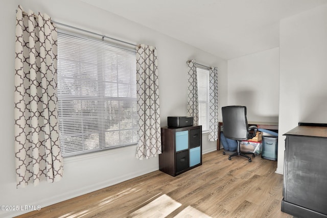 office area featuring baseboards, plenty of natural light, and light wood-style floors