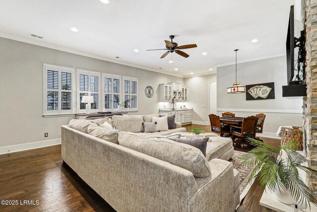 living room with dark hardwood / wood-style flooring, sink, ornamental molding, and ceiling fan