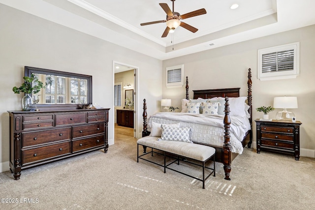 carpeted bedroom with connected bathroom, ornamental molding, a raised ceiling, and ceiling fan