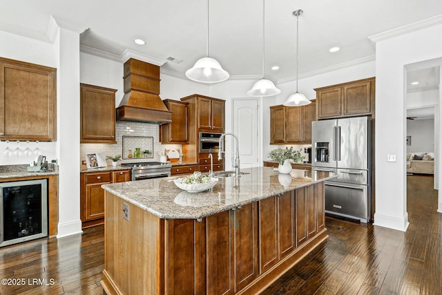 kitchen featuring hanging light fixtures, a center island with sink, wine cooler, and premium appliances