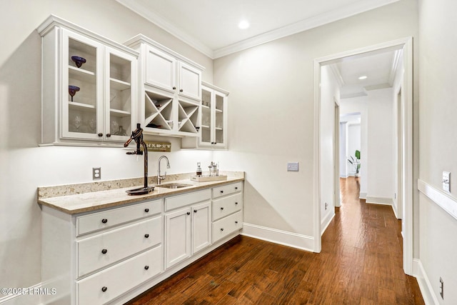 bar featuring sink, ornamental molding, dark hardwood / wood-style floors, light stone countertops, and white cabinets