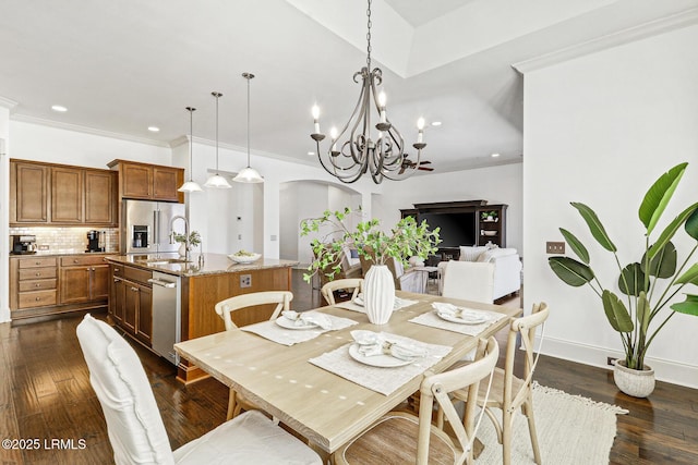 dining room featuring sink, a notable chandelier, ornamental molding, and dark hardwood / wood-style floors