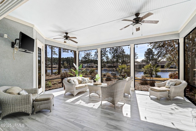 sunroom / solarium with a water view and ceiling fan