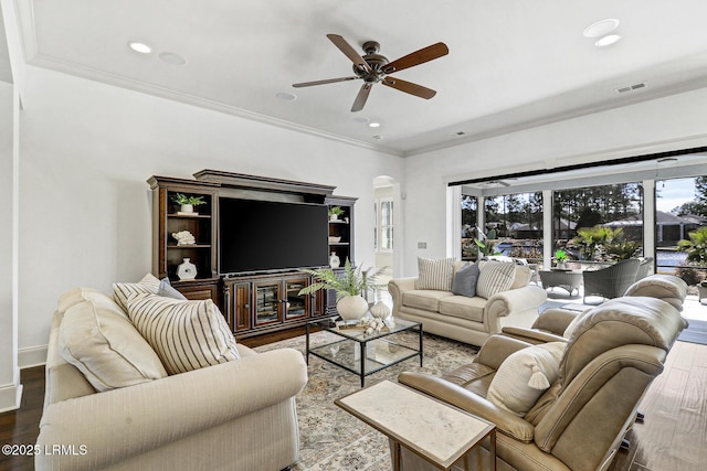 living room featuring ceiling fan, ornamental molding, and wood-type flooring