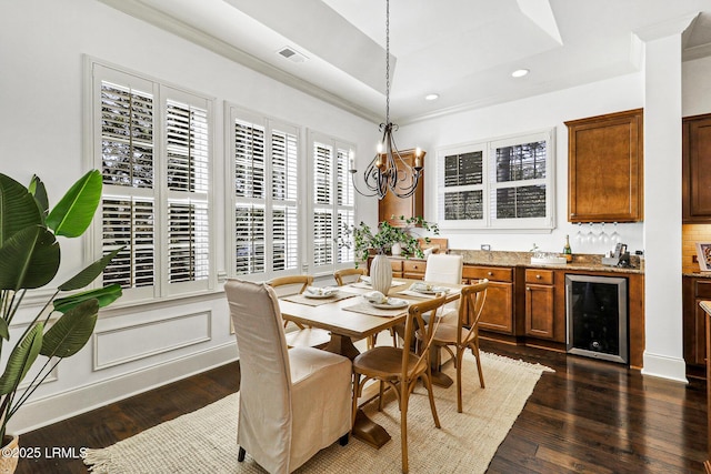 dining room featuring wine cooler, crown molding, a chandelier, indoor bar, and dark hardwood / wood-style floors