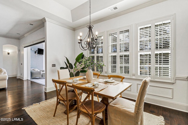 dining room featuring an inviting chandelier, ornamental molding, and dark hardwood / wood-style floors