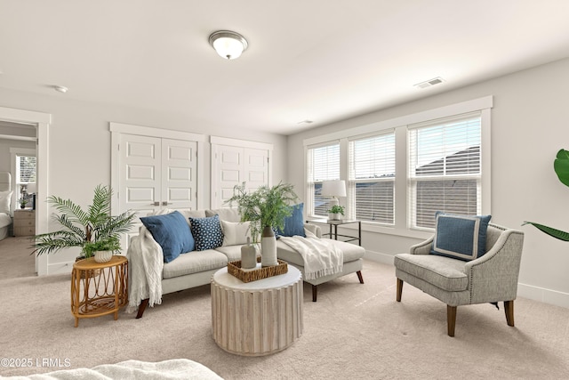 living room featuring light colored carpet, visible vents, and baseboards