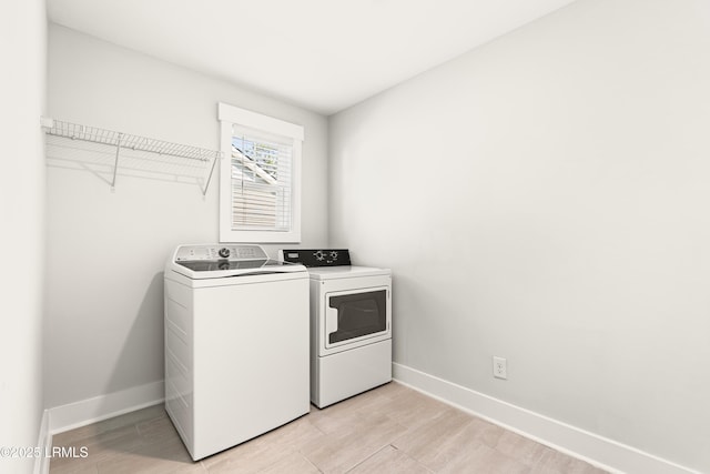 laundry room with laundry area, baseboards, and washer and dryer