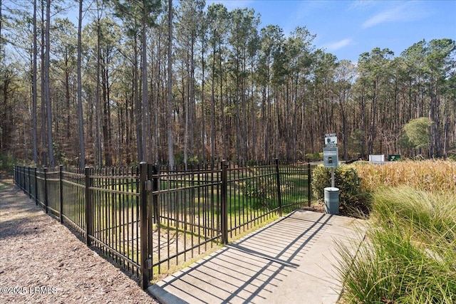 view of gate with fence and a view of trees