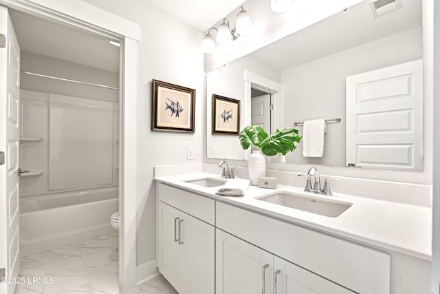 full bathroom featuring toilet, marble finish floor, visible vents, and a sink