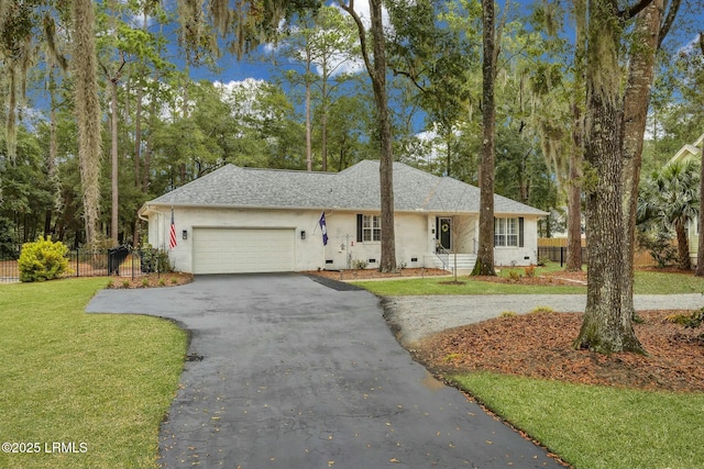 ranch-style house featuring a garage and a front lawn