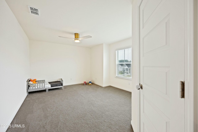 interior space featuring dark colored carpet and ceiling fan