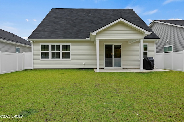 rear view of property with a patio and a lawn