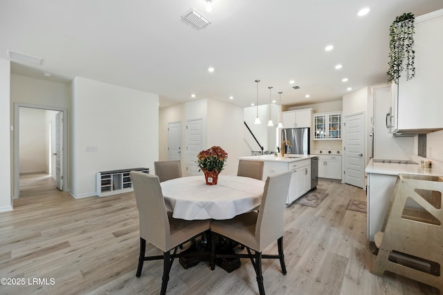 dining room with sink and light hardwood / wood-style flooring