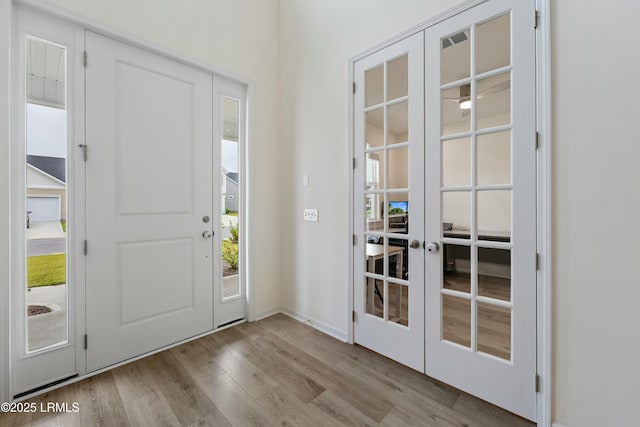 foyer entrance with french doors, plenty of natural light, and light hardwood / wood-style flooring