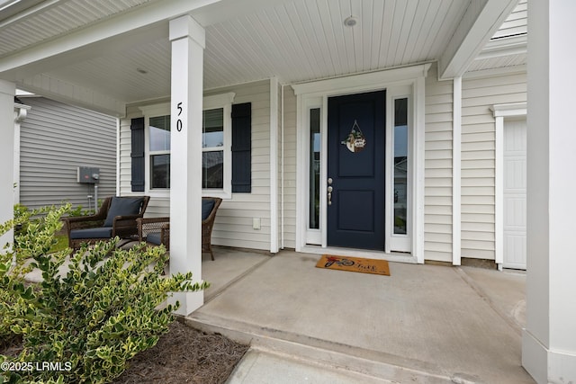 view of exterior entry featuring covered porch