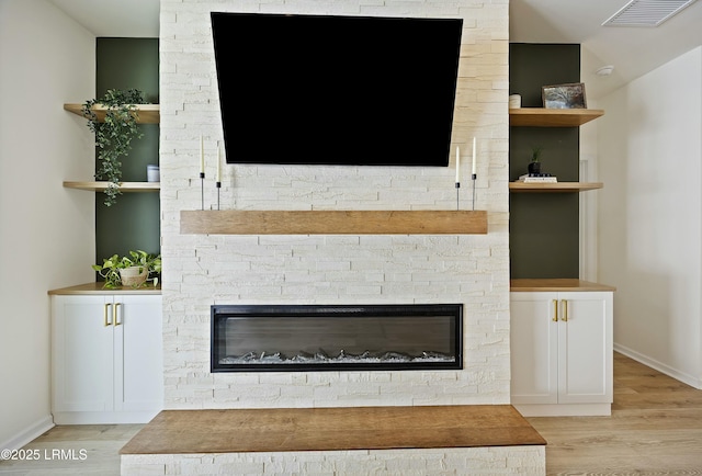 interior details featuring hardwood / wood-style flooring and a stone fireplace