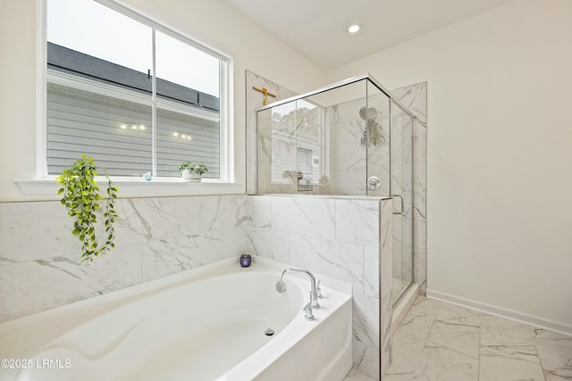 bathroom featuring a wealth of natural light and independent shower and bath