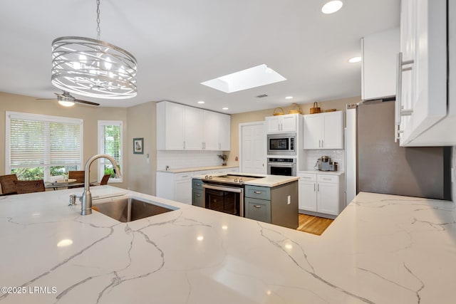 9 Spartina Cres, Bluffton, SC 29910 - kitchen featuring stainless steel appliances, a sink, decorative backsplash, white cabinets, and light stone countertops