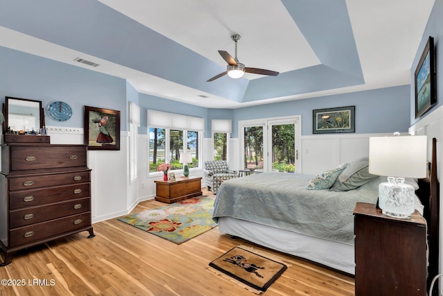 9 Spartina Cres, Bluffton, SC 29910 - bedroom featuring a raised ceiling, light wood-style flooring, a wainscoted wall, and a ceiling fan