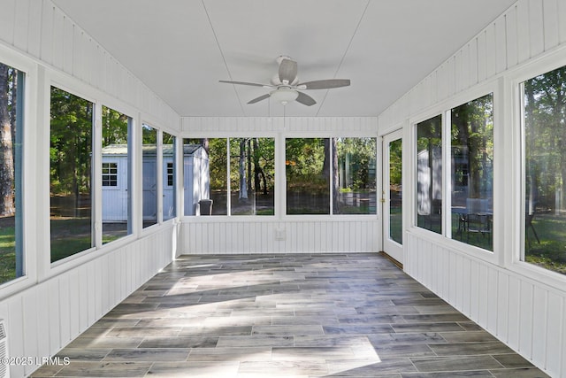 unfurnished sunroom with a ceiling fan and plenty of natural light