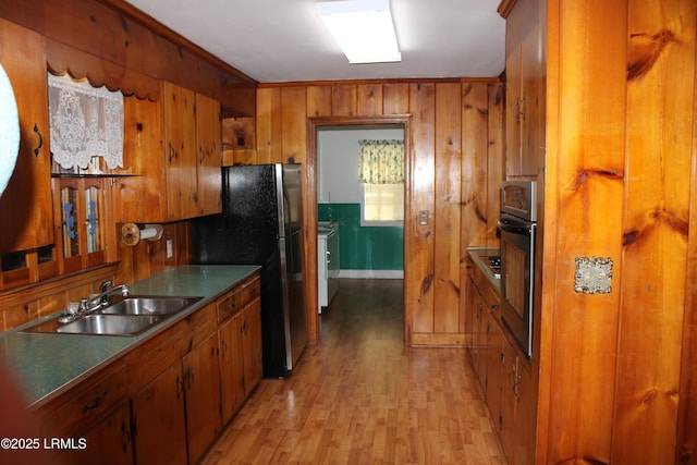 1933 Bamberg Hwy, Hampton, SC 29924 - kitchen featuring a sink, appliances with stainless steel finishes, brown cabinets, light wood finished floors, and wood walls