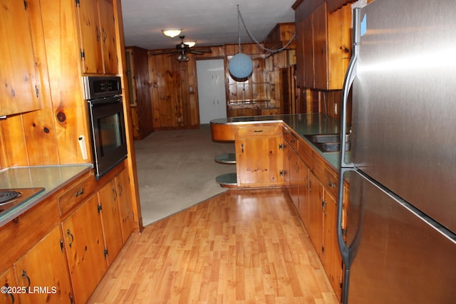 1933 Bamberg Hwy, Hampton, SC 29924 - kitchen featuring freestanding refrigerator, oven, ceiling fan, brown cabinets, and light wood-type flooring