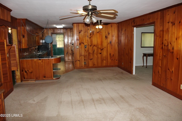 1933 Bamberg Hwy, Hampton, SC 29924 - kitchen with wood walls, carpet flooring, ceiling fan, baseboards, and brown cabinetry